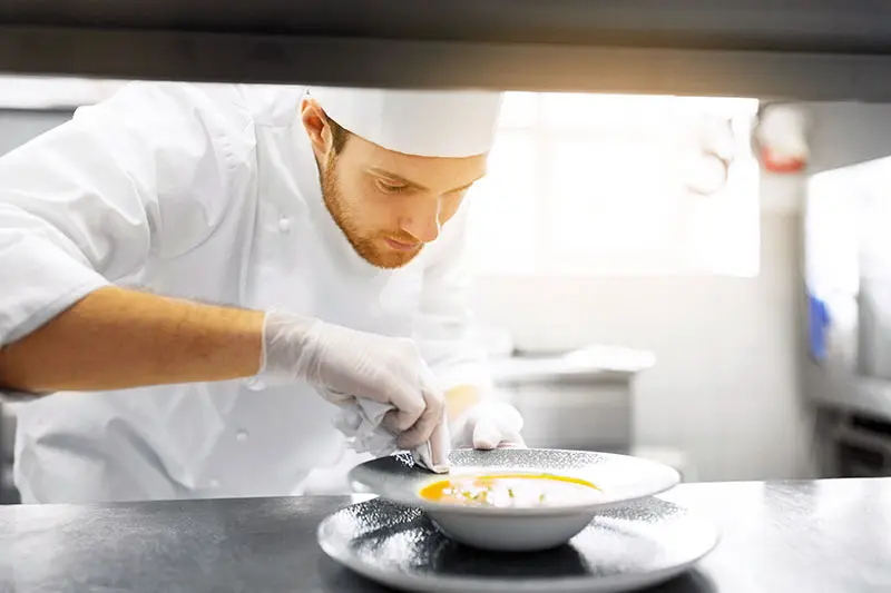 A chef gives his plate the final touch before service